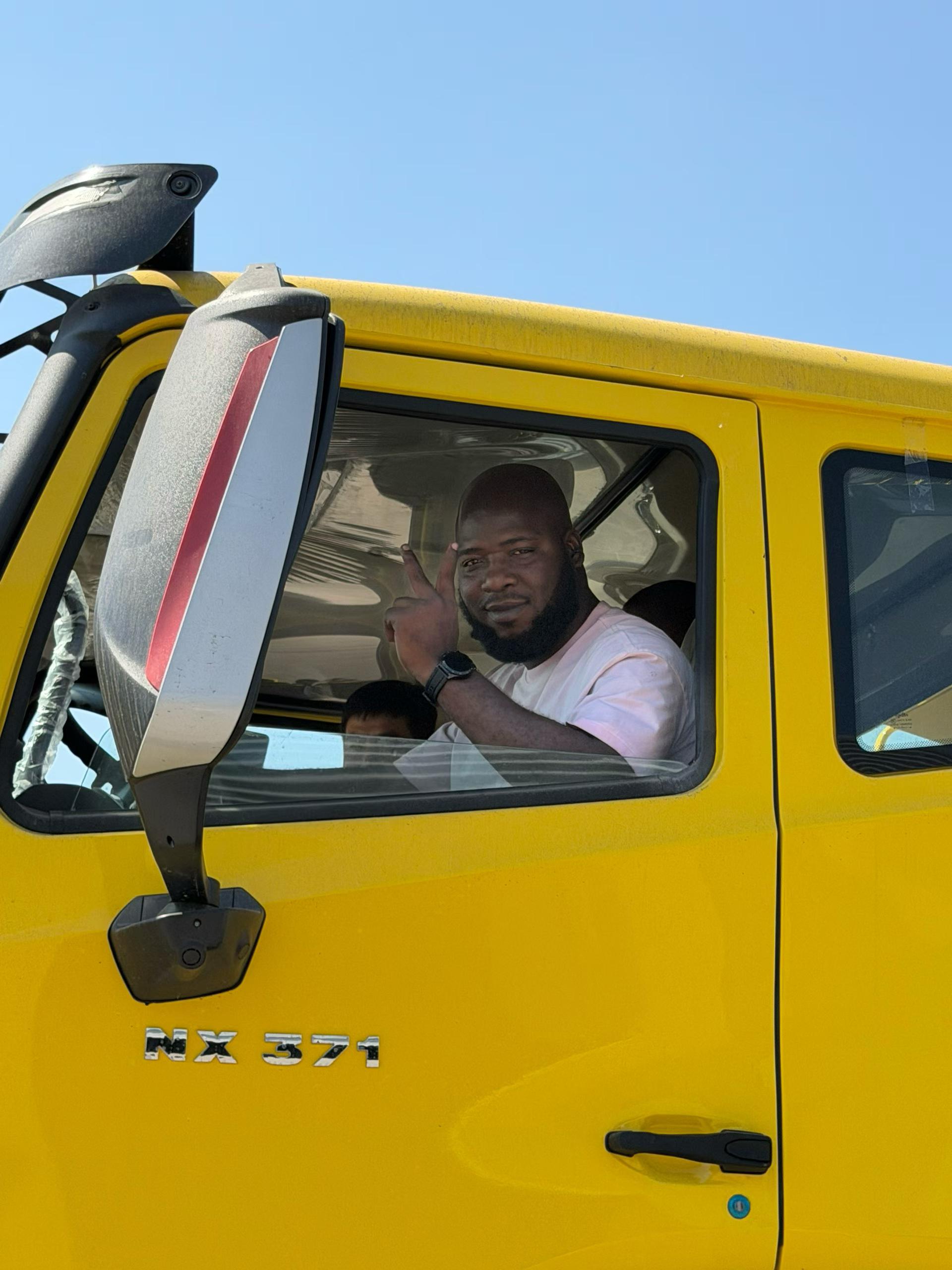 African customer inside the HOWO truck cab during factory visit