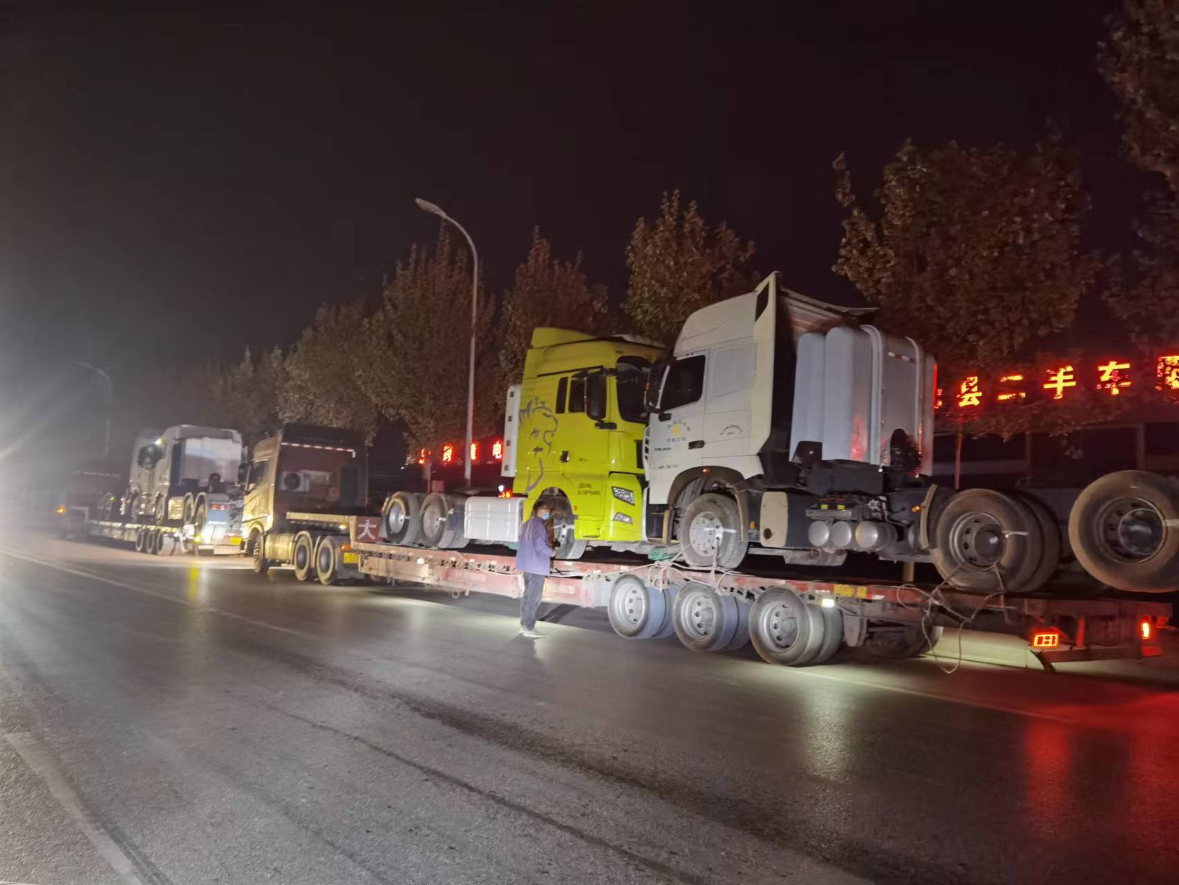 Tractor trucks being secured for shipment to Nigeria