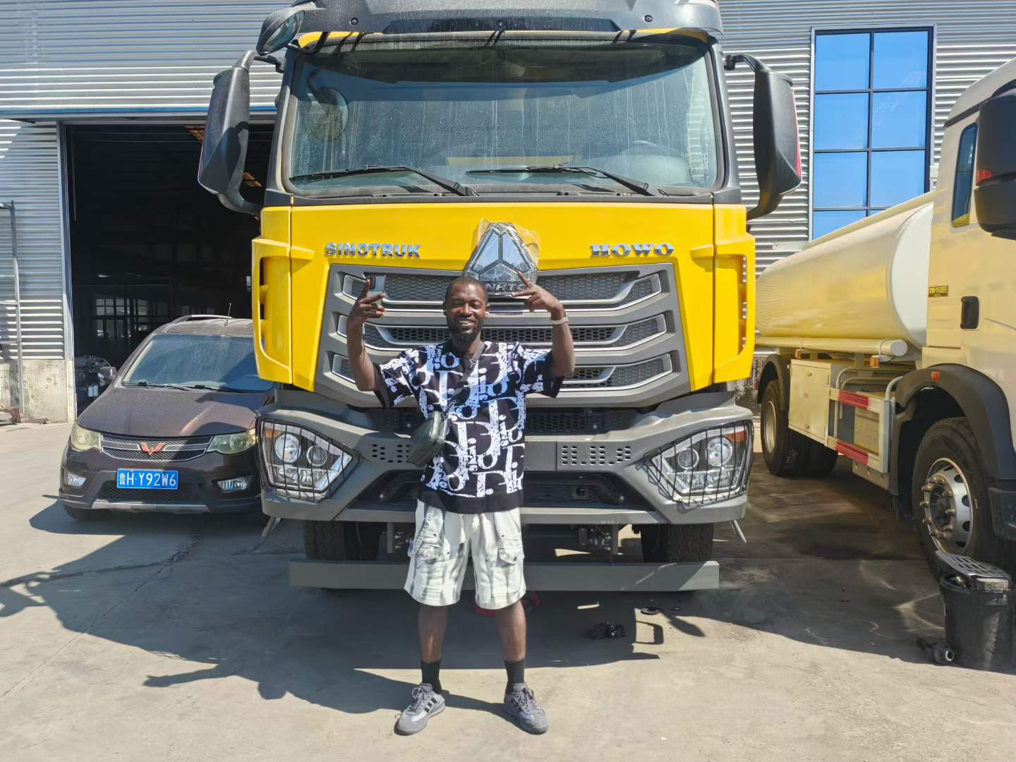 African customer inspecting a yellow SINOTRUK HOWO NX 371 truck
